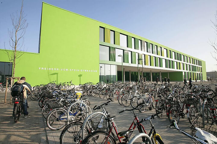 Sichtbetonelemente mit historischen Zitaten im Freiherr-vom-Stein-Gymnasium – gestaltete Betonwände von Lütkenhaus im Zusammenspiel mit Holzverkleidungen